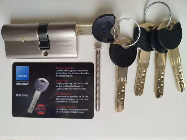 Bombín Tesa de perfil europeo junto a llave anticopia Bombín Tesa de perfil europeo con llave anticopia instalado por cerrajero de Reparhogar
