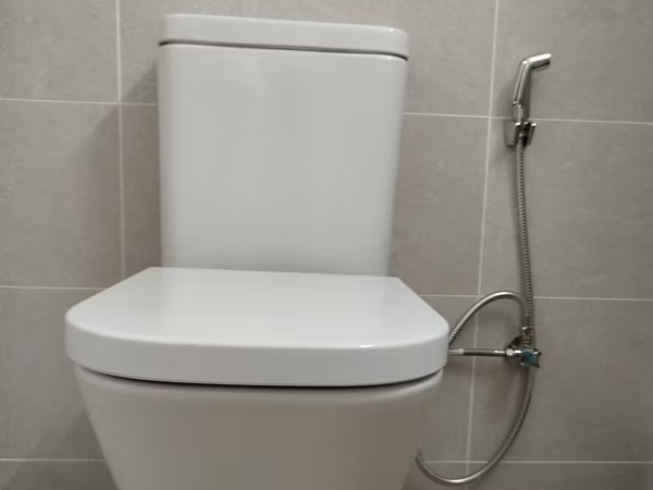 WC con cisterna Roca y ducha higiénica instalada por Reparhogar Barcelona